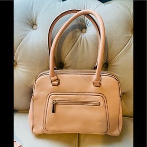 Pink purse with handles and three sections and gold tone zippers and accents.